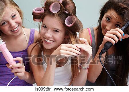 Teenage girls styling their hair View Large Photo Image Stock Image - Teenage girls styling their hair. Fotosearch
