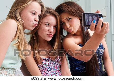 Teenage girls taking a picture of themselves making faces View Large Photo Image Stock Photograph - Teenage girls taking a picture of themselves making faces. Fotosearch
