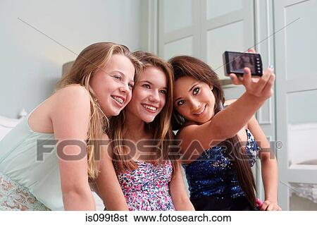 Teenage girls taking a picture of themselves View Large Photo Image Stock Photograph - Teenage girls taking a picture of themselves. Fotosearch
