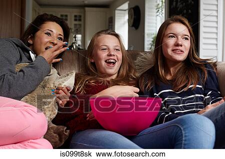 Teenage girls watching movie with popcorn View Large Photo Image Stock Image - Teenage girls watching movie with popcorn. Fotosearch