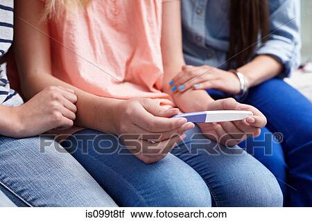 Stock Image - Teenage girls with pregnancy test. Fotosearch