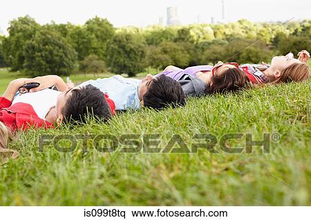 Teenagers lying in a park View Large Photo Image Stock Photography - Teenagers lying in a park. Fotosearch
