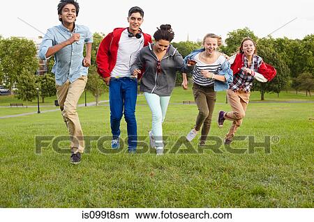 Picture - Teenagers running in a park. Fotosearch