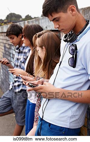 Teenagers using cellphones View Large Photo Image Picture - Teenagers using cellphones. Fotosearch
