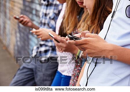 Teenagers using cellphones View Large Photo Image Stock Image - Teenagers using cellphones. Fotosearch