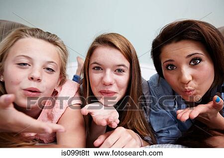 Stock Photograph - Three teenage girls blowing a kiss. Fotosearch