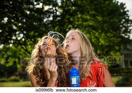 Two girls blowing bubbles with bubble wand View Large Photo Image Stock Image - Two girls blowing bubbles with bubble wand. Fotosearch