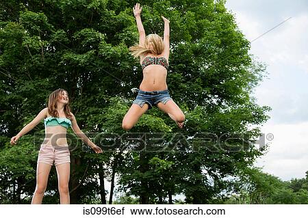 Stock Image - Two girls on trampoline. Fotosearch