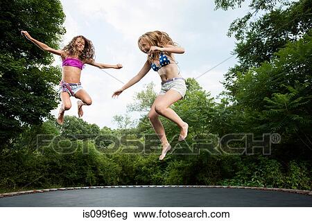 Two girls on trampoline View Large Photo Image Stock Image - Two girls on trampoline. Fotosearch