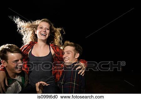 Stock Image - Two male friends lifting teenage girl. Fotosearch
