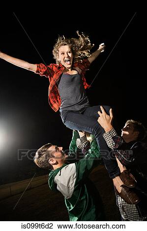 Two male friends lifting teenage girl, arms outstretched View Large Photo Image Stock Image - Two male friends lifting teenage girl, arms outstretched. Fotosearch