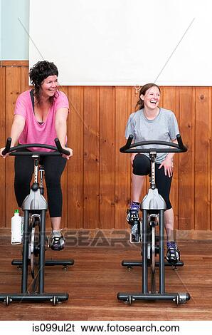 Two women on exercise bikes View Large Photo Image Stock Photograph - Two women on exercise bikes. Fotosearch