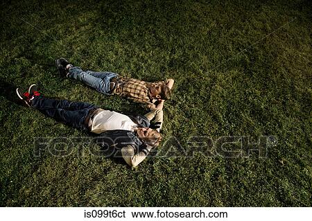 Two young men lying on grass at night, high angle View Large Photo Image Stock Photograph - Two young men lying on grass at night, high angle. Fotosearch