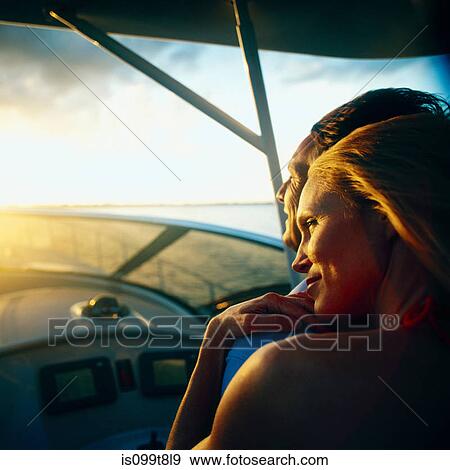 Woman relaxing on man's shoulder on boat at low light View Large Photo Image Stock Photo - Woman relaxing on man's shoulder on boat at low light. Fotosearch