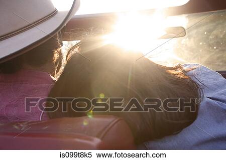 Woman resting head on boyfriend's shoulder as he drives in sunlight View Large Photo Image Stock Photography - Woman resting head on boyfriend's shoulder as he drives in sunlight. Fotosearch