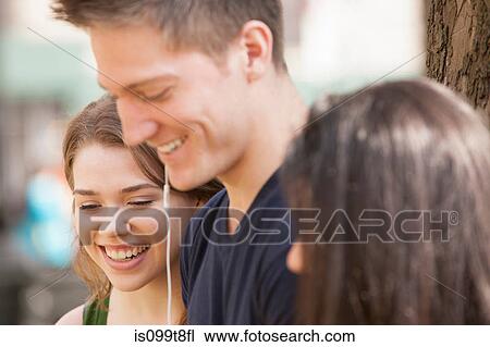 Stock Image - Young adults sharing music. Fotosearch