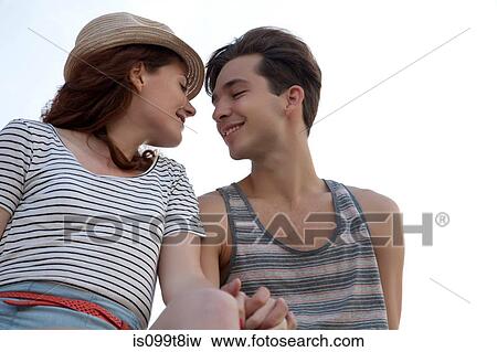 Stock Photo - Young couple holding hands, portrait. Fotosearch