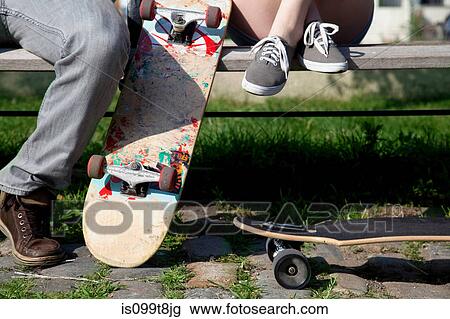 Young couple on bench with skateboards, low section View Large Photo Image Stock Image - Young couple on bench with skateboards, low section. Fotosearch