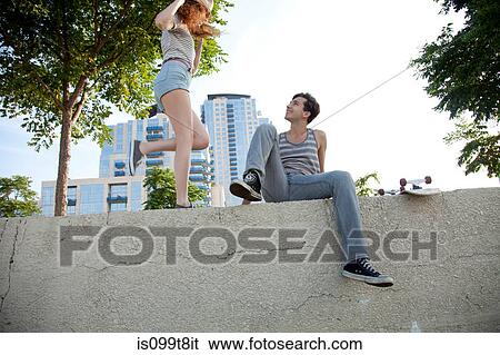 Young couple on wall View Large Photo Image Stock Photograph - Young couple on wall. Fotosearch