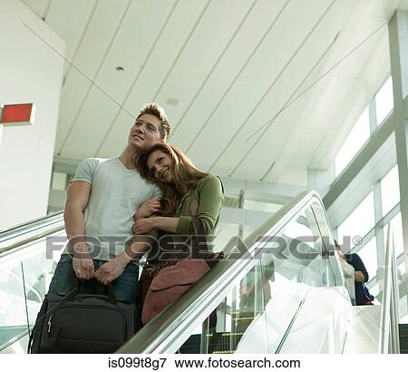 Young couple travelling on escalator View Large Photo Image Stock Photo - Young couple travelling on escalator. Fotosearch