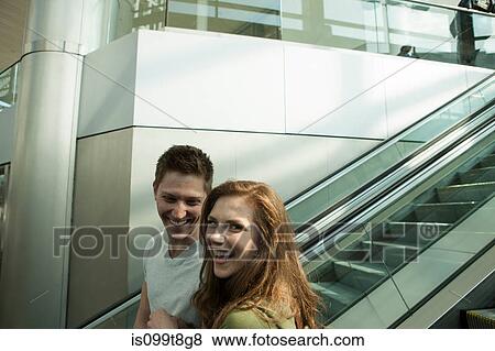 Young couple travelling on escalator View Large Photo Image Stock Photo - Young couple travelling on escalator. Fotosearch