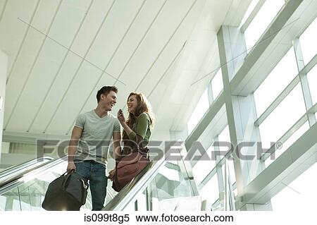 Young couple travelling on escalator View Large Photo Image Stock Photography - Young couple travelling on escalator. Fotosearch