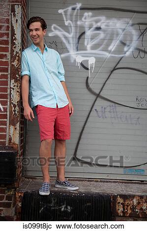 Young man standing in front of graffiti, portrait View Large Photo Image Stock Image - Young man standing in front of graffiti, portrait. Fotosearch
