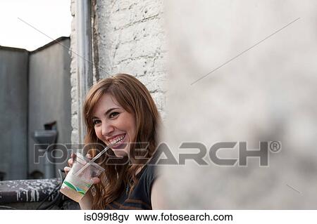 Young woman drinking and smiling View Large Photo Image Stock Photo - Young woman drinking and smiling. Fotosearch