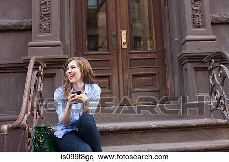 Young woman in steps of building with cellphone View Large Photo Image Stock Photography - Young woman in steps of building with cellphone. Fotosearch