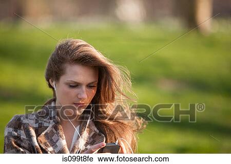Stock Image - Young woman listening to music. Fotosearch