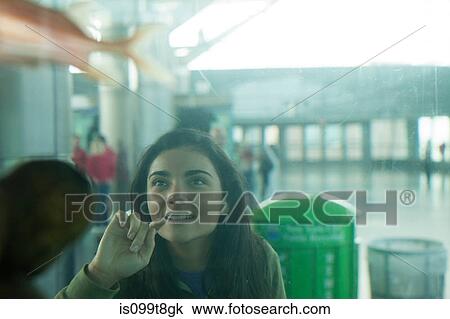 Young woman looking into an aquarium View Large Photo Image Stock Image - Young woman looking into an aquarium. Fotosearch