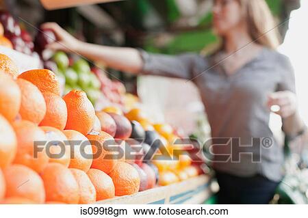 Young woman picking out fruit from stall View Large Photo Image Picture - Young woman picking out fruit from stall. Fotosearch