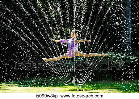 Ballerina leaping through a water sprinkler View Large Photo Image Stock Photography - Ballerina leaping through a water sprinkler. Fotosearch