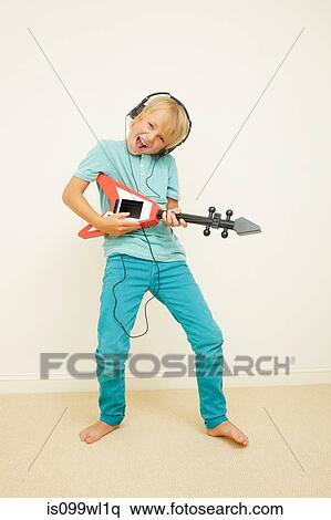 Boy wearing headphones playing guitar View Large Photo Image Stock Photography - Boy wearing headphones playing guitar. Fotosearch