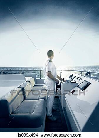 Captain at helm of large motor yacht View Large Photo Image Picture - Captain at helm of large motor yacht. Fotosearch