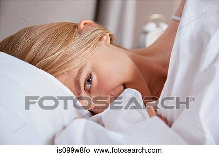 Picture - Close up of young woman in bed. Fotosearch