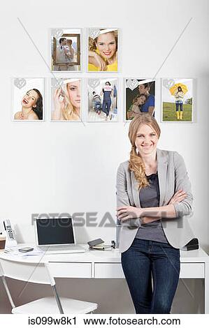 Stock Image - Confident young woman in magazine office. Fotosearch