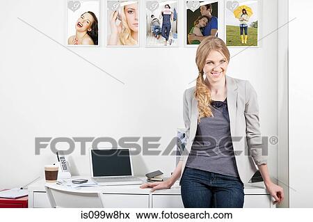 Confident young woman in magazine office View Large Photo Image Stock Photo - Confident young woman in magazine office. Fotosearch