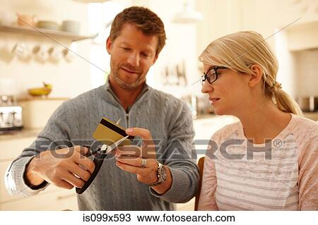 Couple cutting credit card with scissors View Large Photo Image Stock Image - Couple cutting credit card with scissors. Fotosearch