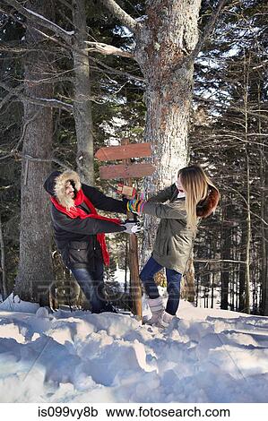 Couple fighting over wooden sign in forest View Large Photo Image Stock Image - Couple fighting over wooden sign in forest. Fotosearch