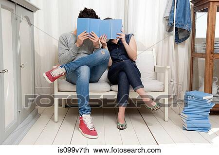 Couple hiding behind books View Large Photo Image Stock Image - Couple hiding behind books. Fotosearch