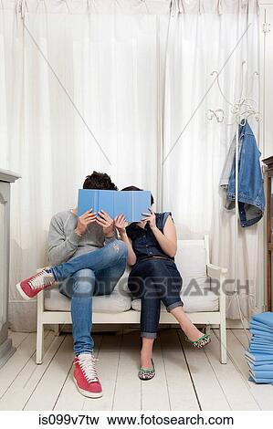 Couple hiding behind books View Large Photo Image Stock Photo - Couple hiding behind books. Fotosearch