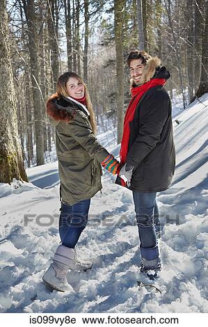 Stock Image - Couple holding hands in snow. Fotosearch