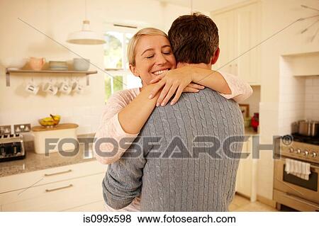 Couple hugging in kitchen View Large Photo Image Stock Photo - Couple hugging in kitchen. Fotosearch