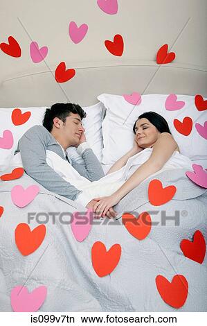 Couple in bed with heart shapes on bedclothes View Large Photo Image Picture - Couple in bed with heart shapes on bedclothes. Fotosearch