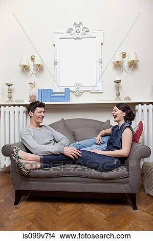 Couple laughing on sofa View Large Photo Image Picture - Couple laughing on sofa. Fotosearch