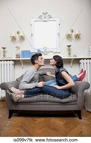 Stock Image - Couple on sofa kissing. Fotosearch