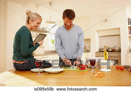 Couple preparing food in kitchen View Large Photo Image Stock Image - Couple preparing food in kitchen. Fotosearch