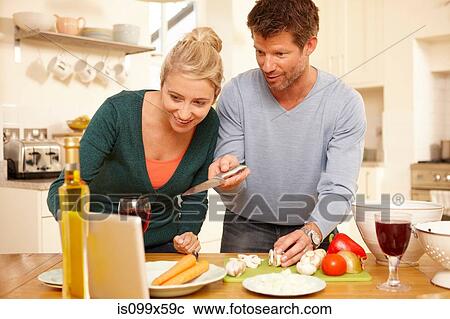 Stock Image - Couple preparing food in kitchen. Fotosearch