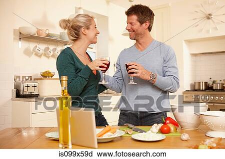 Couple preparing food in kitchen View Large Photo Image Stock Image - Couple preparing food in kitchen. Fotosearch